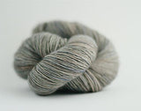 Madelinetosh Tosh DK yarn in a soft, fallen cloud colorway, showcasing the wool fiber and vibrant, earthy tones.