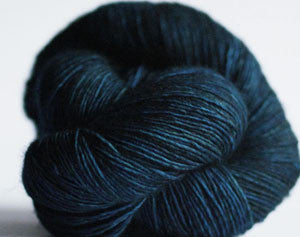 Madelinetosh Tosh DK yarn in deep color, showing soft wool texture and vibrant dye, ideal for knitting and crochet projects.