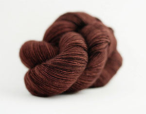 Madelinetosh Tosh DK yarn in resin color, soft and lightweight wool blend for knitting or crocheting projects.