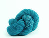Close-up of Madelinetosh Tosh DK yarn in vibrant colors, showcasing its soft texture and wool blend for knitting projects.