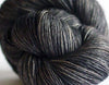 Madelinetosh Tosh DK yarn in leopard print with tan and black tones, showcasing soft, twisted fiber strands for knitting or crocheting.