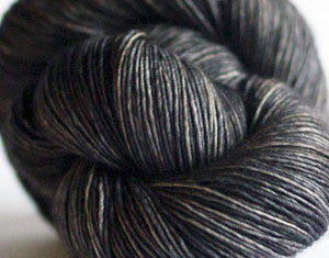 Madelinetosh Tosh DK yarn in leopard print with tan and black tones, showcasing soft, twisted fiber strands for knitting or crocheting.