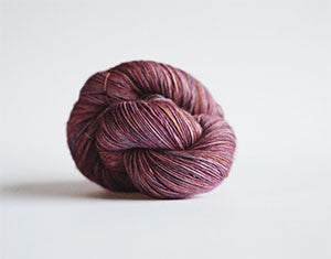 Madelinetosh Tosh DK yarn in kilim colorway, soft wool skein suitable for knitting or crochet projects.