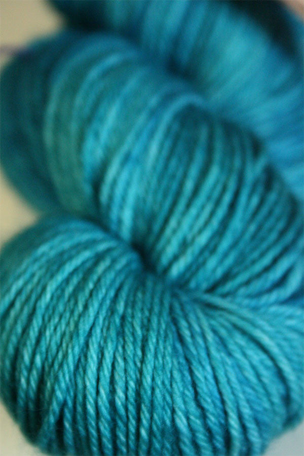 Madelinetosh Tosh DK yarn ball in vibrant multicolor shades, showcasing soft, hand-dyed wool for knitting or crochet projects.