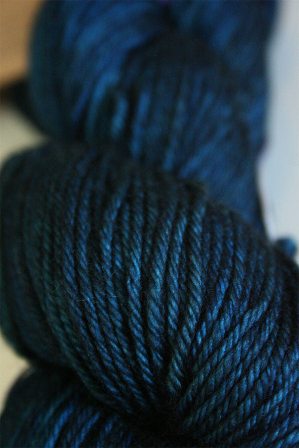 Madelinetosh Tosh DK yarn in deep, rich color, showcasing soft wool texture and vibrant tone for knitting or crochet projects.