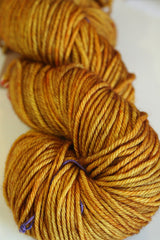 Madelinetosh Tosh DK yarn in Daffodil, showing vibrant yellow color and soft texture of the wool skein.