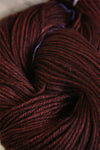 Close-up of Madelinetosh Tosh DK yarn in resin color, showcasing soft, variegated wool yarn with a smooth texture.