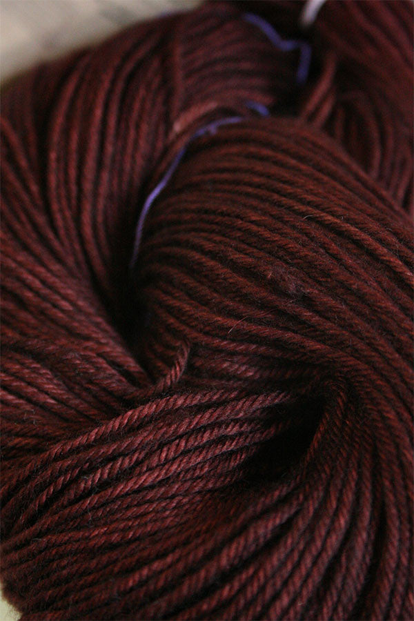 Close-up of Madelinetosh Tosh DK yarn in resin color, showcasing soft, variegated wool yarn with a smooth texture.
