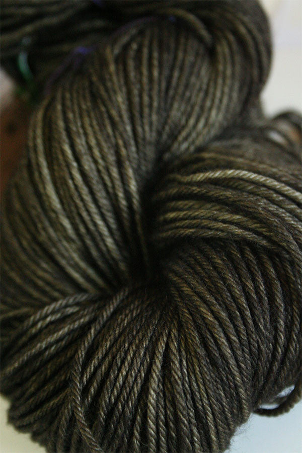 Madelinetosh Tosh DK yarn in Twig color, showing soft, lightweight wool skein with rich, earthy green tones.