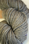 Madelinetosh Tosh DK yarn in a soft, multicolored skein with vibrant purple, pink, and blue tones, perfect for knitting projects.