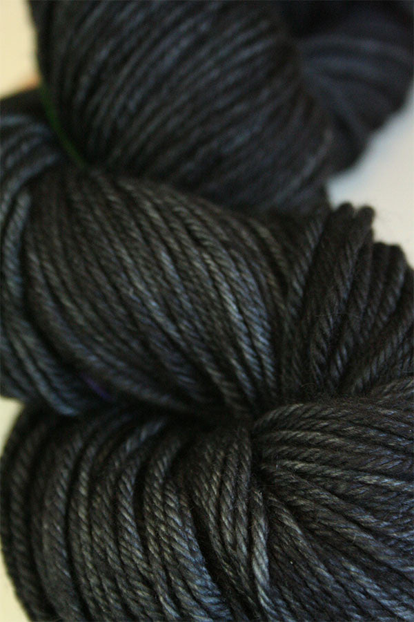 Madelinetosh Tosh DK yarn in leopard print with tan, black, and brown tones, showcasing soft, textured wool yarn for knitting or crochet.