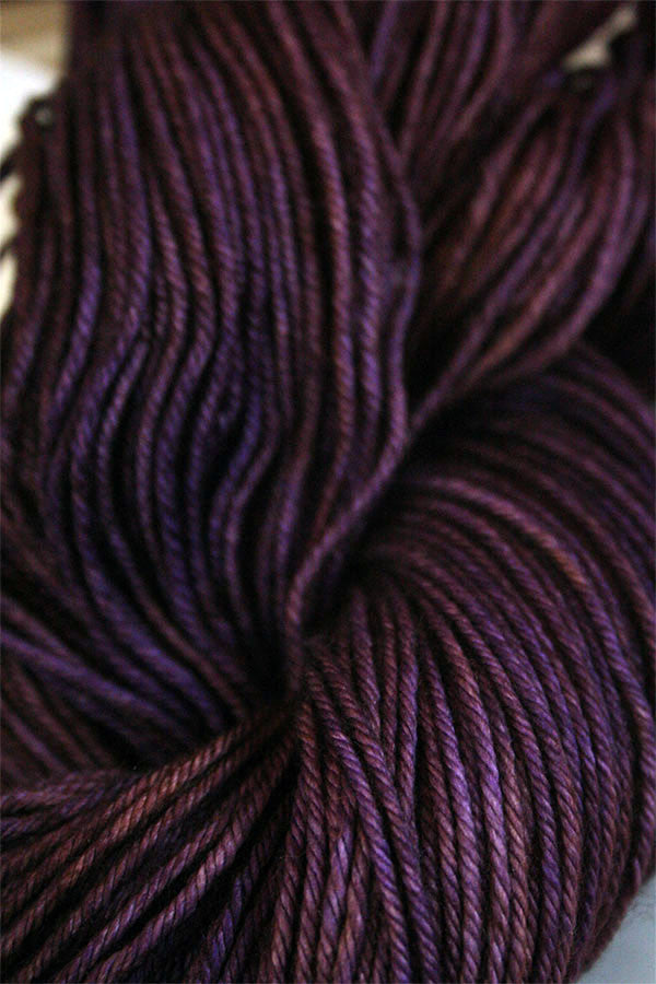 Close-up of Madelinetosh Tosh DK yarn in Geode colorway, showing soft, hand-dyed wool fibers with subtle variegation and rich texture.