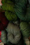 Madelinetosh Tosh DK yarn skeins in vibrant colors, arranged in a group, showcasing the soft, chunky texture of the Tosh DK brand.