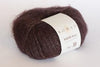 Close-up of Rowan Kidsilk Haze yarn skein showcasing its soft, delicate pink and lavender fibers with a smooth texture.