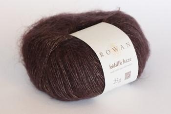 Close-up of Rowan Kidsilk Haze yarn skein showcasing its soft, delicate pink and lavender fibers with a smooth texture.