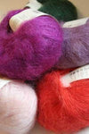 Colorful skeins of Rowan Kidsilk Haze yarn arranged in a group shot, showcasing soft, lightweight knitting and crochet material.