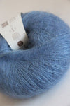 Soft, multicolored Rowan Kidsilk Haze yarn skein with a twisted, fluffy texture, ideal for delicate knitting projects.