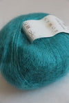 Soft, multicolored Rowan Kidsilk Haze yarn skein with delicate blending of pastel shades, ideal for knitting or crochet projects.