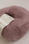 Close-up of Rowan Kidsilk Haze yarn in soft, multicolored strands, showcasing its lightweight, delicate texture for knitting or crochet projects.