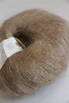 Rowan Kidsilk Haze yarn in a soft mud color, showing the delicate, lightweight fiber with subtle sheen and fine texture.