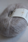 Rowan Kidsilk Haze yarn in soft pearl color, showcasing delicate, lightweight fiber ideal for knitting and crochet projects.