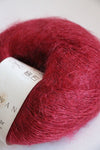 Close-up of Rowan Kidsilk Haze yarn in blood color, showcasing its soft, delicate fibers and fine texture.
