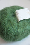 Soft, multicolor Rowan Kidsilk Haze yarn ball with shades of green and cream, showcasing its delicate, lightweight texture.