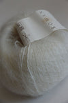 Rowan Kidsilk Haze yarn in creme color, soft and lightweight with a delicate, fuzzy texture, suitable for knitting and crochet projects.