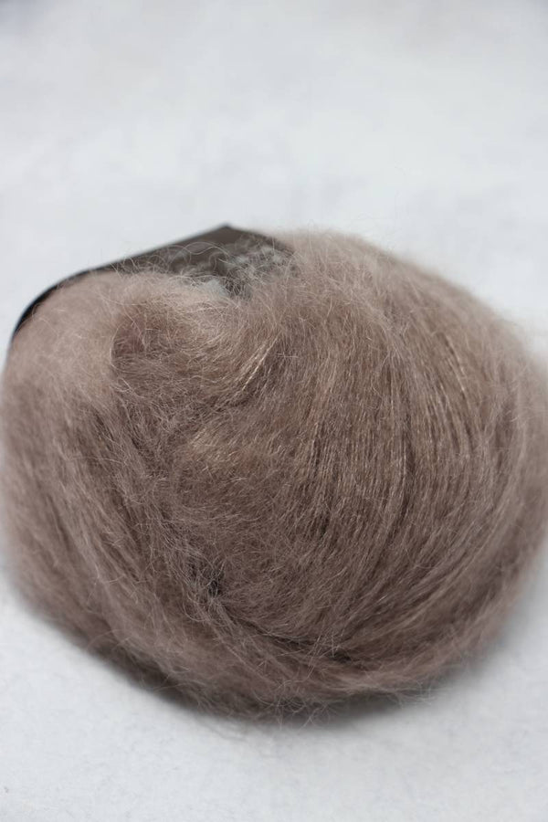 Soft Rowan Kidsilk Haze yarn in a natural branch color, showcasing its delicate, lightweight texture ideal for knitting and crochet projects.