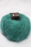 Soft Rowan Kidsilk Haze yarn in a shimmering gem color, showing a close-up of the delicate, lightweight fiber with a subtle sheen.