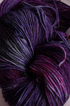 Close-up of Zen Yarn Garden Serenity 20 fingering weight yarn in petunia color, showing soft, vibrant purple fibers and texture.