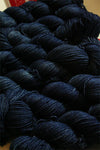 Fingering weight yarn in navy blue from Zen Yarn Garden's Serenity 20 collection, with soft, smooth texture and subtle color variations.