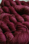 Fingering weight yarn from Zen Yarn Garden's Serenity 20 collection in soft blush pink, showcasing smooth, twisted fibers.