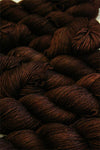 Fingering weight yarn from Zen Yarn Garden's Serenity 20 collection in a warm, rich chestnut color, displayed in skein form.