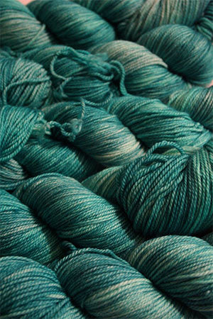 Fingering weight yarn from Zen Yarn Garden's Serenity 20 collection in soft menthol green, showcasing smooth, spun fibers.