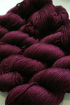 Fingering weight yarn from Zen Yarn Garden's Serenity 20 collection in rich merlot color, showcasing soft fiber and smooth texture.