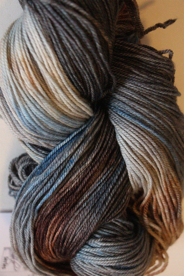Fingering weight yarn from Zen Yarn Garden's Serenity 20 collection in soft blue and nude tones, with a smooth, variegated texture.