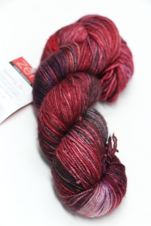 Fingering weight yarn from Zen Yarn Garden's Serenity 20 collection, colorway Vixen, showing soft, vibrant fibers and texture.