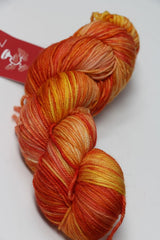 Fingering weight yarn from Zen Yarn Garden's Serenity 20 collection in a vibrant, crush-colored skein with soft, textured fibers.