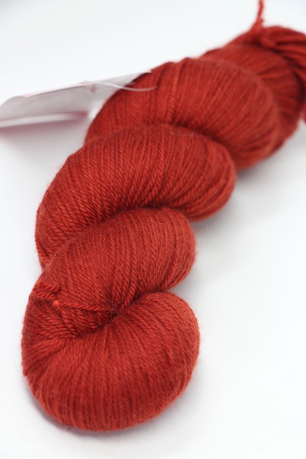 Fingering weight yarn called Serenity 20 by Zen Yarn Garden in saffron color, showing soft, smooth fiber texture.